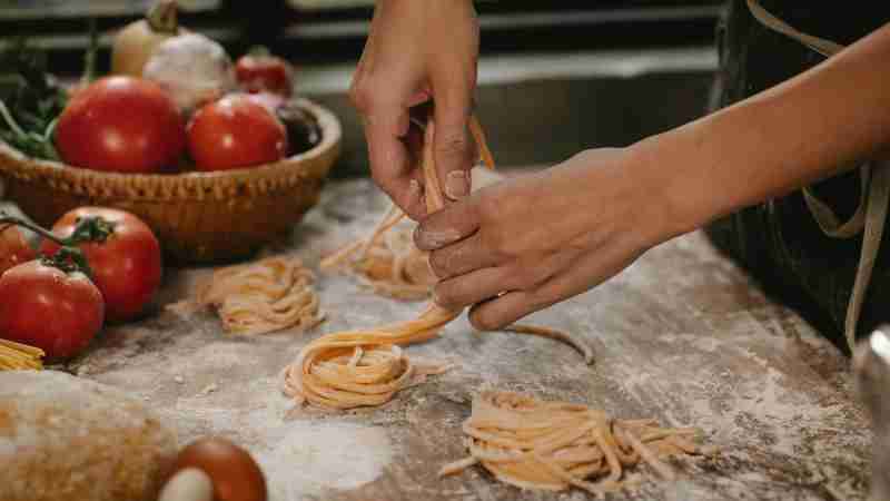 Crop anonymous female chef making homemade Italian pasta nests while cooking in modern kitchen, tags: buona tavola generationen - pexel