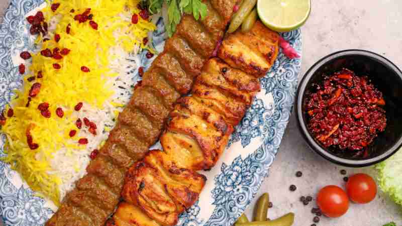 A flavorful Persian kebab dish with saffron rice, grilled meats, and vibrant sides., tags: der pardis hove - pexel