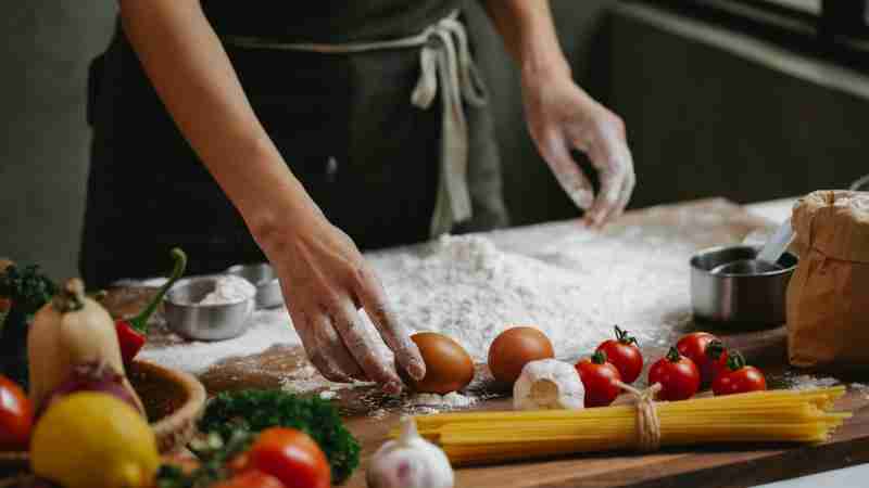 Chef preparing Italian dish with fresh ingredients like pasta, tomatoes, and flour., tags: food und drinks - pexel