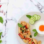 Delicious Thai basil chicken dish with rice and fried egg garnished with chili and cucumber., tags: mediterrane für - pexel